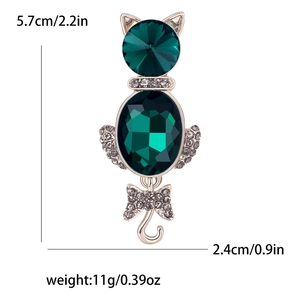 Elegant cat brooch in gold metal with deep green faceted stones and white rhinestones