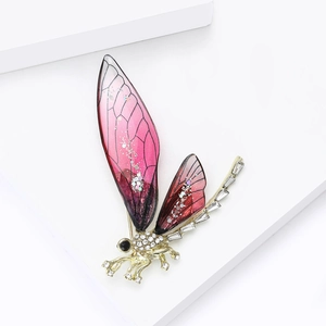 Dettaglio macro della spilla libellula con resina rosa viola e strass bianchi lucidi