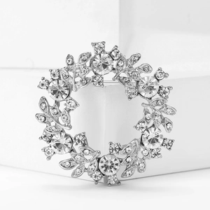 Broche couronne élégante en argent avec cristaux scintillants sur fond blanc épuré