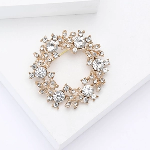 Détail de la broche couronne florale en cristal avec strass sur base en métal doré