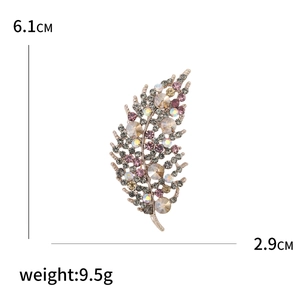 Eleganter Blatt-Brosche mit bunten Strasssteinen und Maßen auf weißem Hintergrund