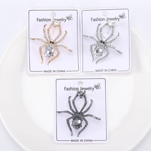 Detailed close-up of spider brooches with crystals in gold, silver, and gunmetal finishes