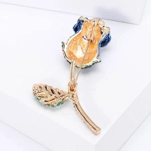 Spilla rosa elegante in oro con petali blu e foglie verdi, vista posteriore con chiusura
