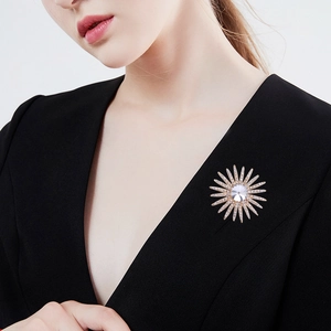 Elegante spilla a forma di sole dorato con strass su una giacca nera da donna