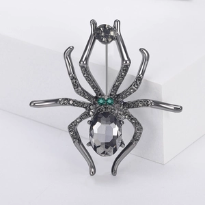 Detailed view of gunmetal spider brooch featuring gray crystals and green rhinestone eyes