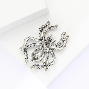 Macro shot of vintage spider brooch back with metal pin closure and green rhinestones
