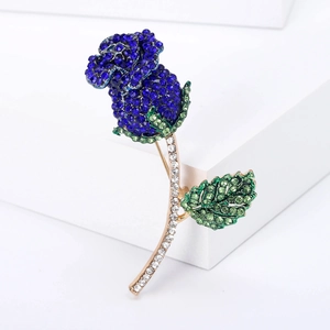 Elegante spilla a rosa in cristallo con fiore blu scuro e foglie di strass verdi