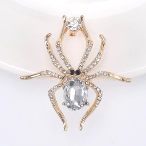 Macro shot of gold spider brooch featuring large oval crystal and pavé rhinestones