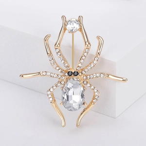 Spider brooch pin in gold alloy with clear rhinestones and large oval crystal center