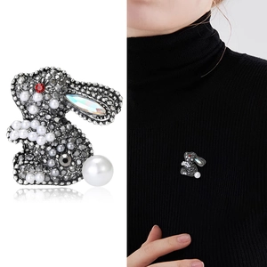 Creative rhinestone rabbit brooch with pearls pinned on a stylish black sweater