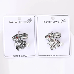 Macro detail of rhinestone bunny brooches with white pearls and red gem eyes