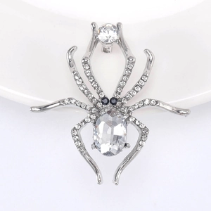 Detailed macro view of a luxury silver spider brooch with clear oval gemstone and rhinestones