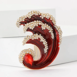 Detail of red enamel ocean wave brooch with sparkling rhinestones and drop-shaped gemstone