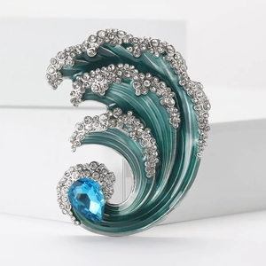 Macro detail of wave brooch with deep blue enamel and sparkling white rhinestones