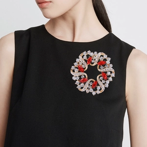 Funkelnde Strass-Kranz-Brosche auf schwarzem Kleid für ein elegantes Styling