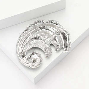 Close-up of the silver ocean wave brooch back showing the secure safety pin fastener