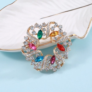 Nahaufnahme der farbenfrohen Strass-Kranz-Brosche mit Goldbasis und bunten Edelsteinen