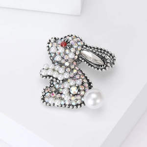 Detailed close-up of a rabbit brooch featuring rainbow rhinestones and white pearls