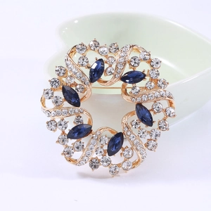 Nahaufnahme der eleganten Goldlegierung-Brosche mit Strass und blauen Kristallen