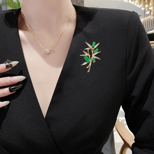 Spilla in bambù dorato con pietre marquise verdi e accenti in zircone