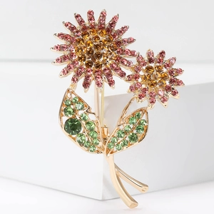 Detailed macro view of elegant sunflower brooch with pink orange and green crystals