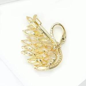 Detailed side view of a gold swan brooch with yellow marquise zirconia and fine crystals