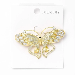 Detailed macro view of gold butterfly brooch with zircon inlays on jewelry display card