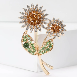 Detailed close-up of sunflower brooch with amber crystal and green leaf rhinestones