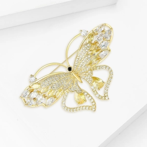 Exquisite gold butterfly brooch with shimmering zircons on a white geometric base