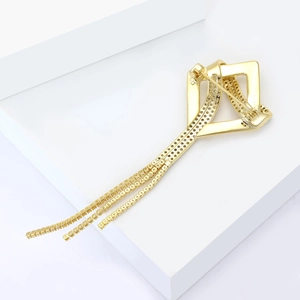 Detail view of crystal geometric brooch with golden fringe tassels and zirconia inlays