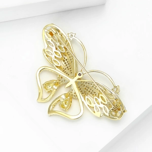 Close-up of golden butterfly brooch with yellow zircons and hollow wing design details
