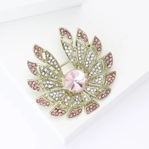 Élégante broche fleur en alliage doré avec strass roses et blancs sur un socle blanc pur