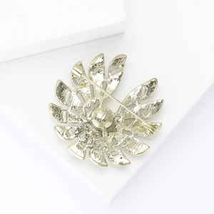 Vue arrière détaillée d'une broche feuille dorée avec métal texturé et fermoir à épingle