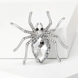 Macro detail of silver spider brooch with sparkling crystals and a large teardrop stone