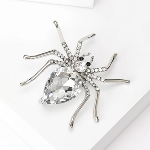 Silver spider brooch with crystal rhinestones and teardrop gemstone on white background