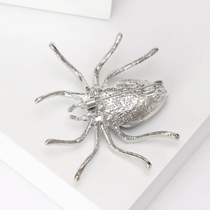 Detailed back view of silver alloy spider brooch showing safety pin and textured finish