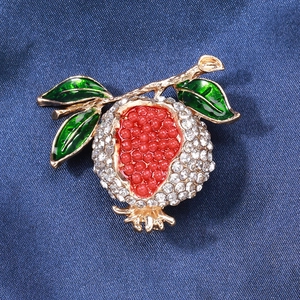 Broche grenade élégante avec strass blancs et perles rouges sur tissu bleu