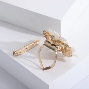 Élégante broche camélia dorée et boucle de foulard avec pétales blancs et cristal rose