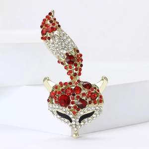 Broche renard exquise en or avec strass rouges et blancs sur un support blanc épuré
