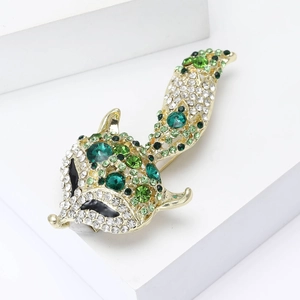 Vue détaillée de la broche renard ornée de cristaux vert émeraude sur métal doré
