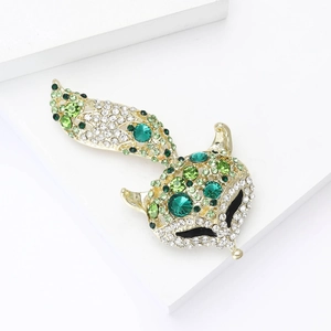 Détail de la broche renard sertie de strass verts et blancs sur métal doré brillant