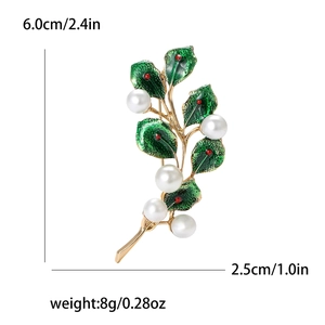 Detail of leaf brooch with green enamel, red beads and white pearls on gold frame