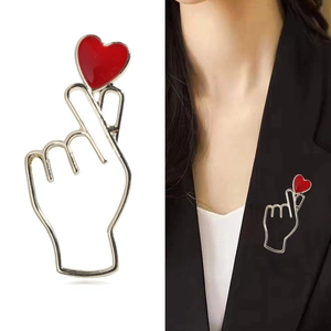 Broche créative geste de cœur en métal doré avec cœur en émail rouge sur revers noir