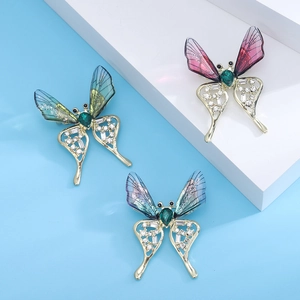 Detailed close-up of butterfly brooches with colorful translucent wings and crystal accents