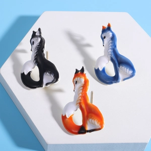 Cute enamel fox brooches in three colors displayed on minimalist geometric platforms