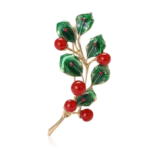 Golden alloy brooch featuring enamel green leaves and six red holly berry accents