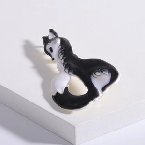 Detail of cute fox brooch with black and white enamel finish on geometric display stand
