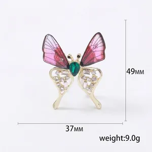Gold butterfly brooch with red wings and green gemstone inlay, 49mm x 37mm