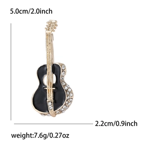 Detail of cello brooch with black enamel, golden strings and inlaid white crystals