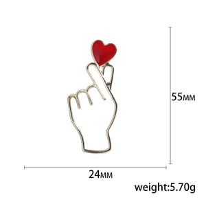 Broche geste de cœur doré avec détail cœur rouge et dimensions de 55 mm par 24 mm